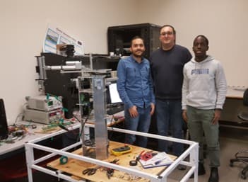 Team with the robotic arm setup in the SFU lab